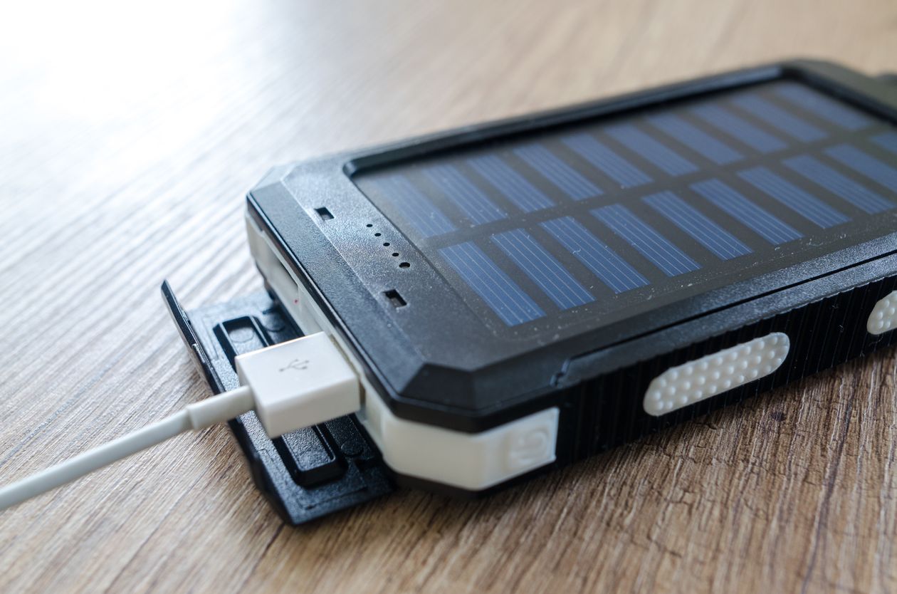Foldable solar power bank charging a device outdoors