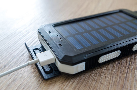 Foldable solar power bank charging a device outdoors