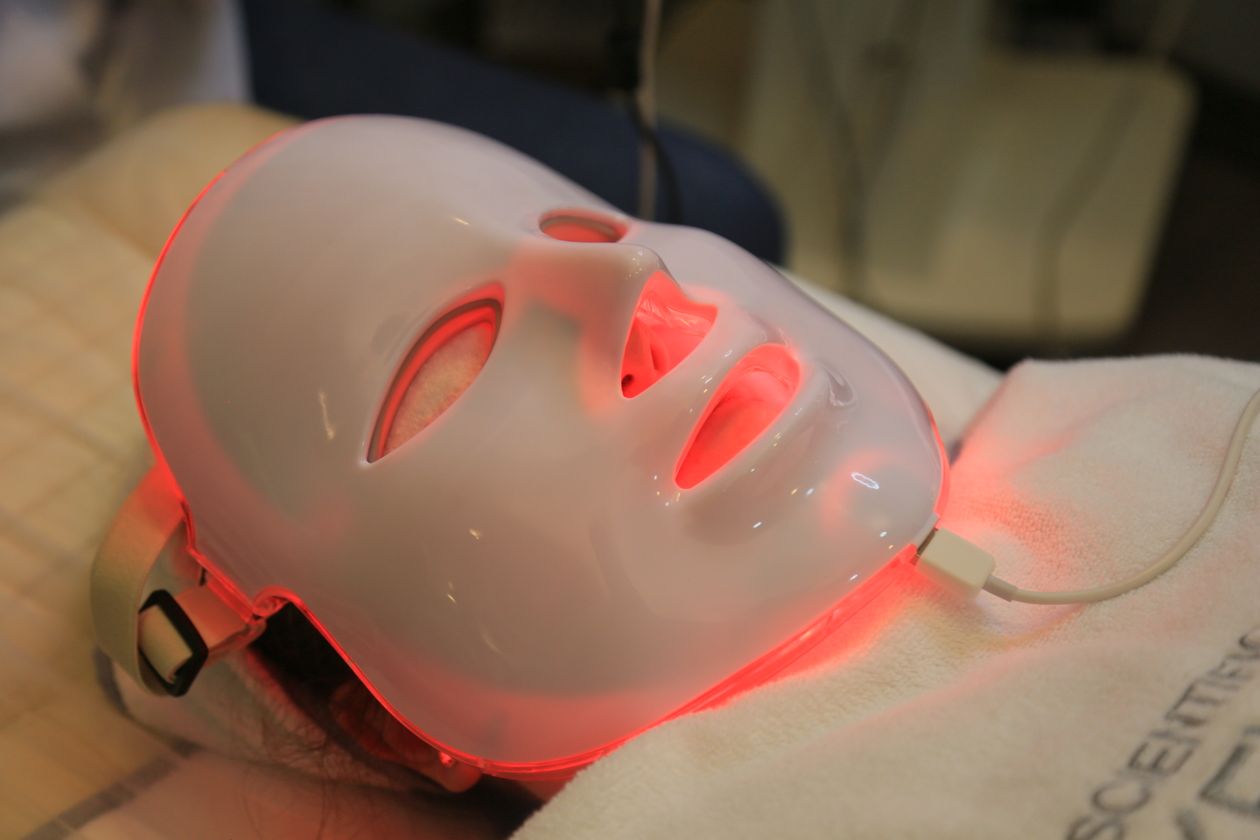 Red light therapy LED face mask glowing red during a treatment session